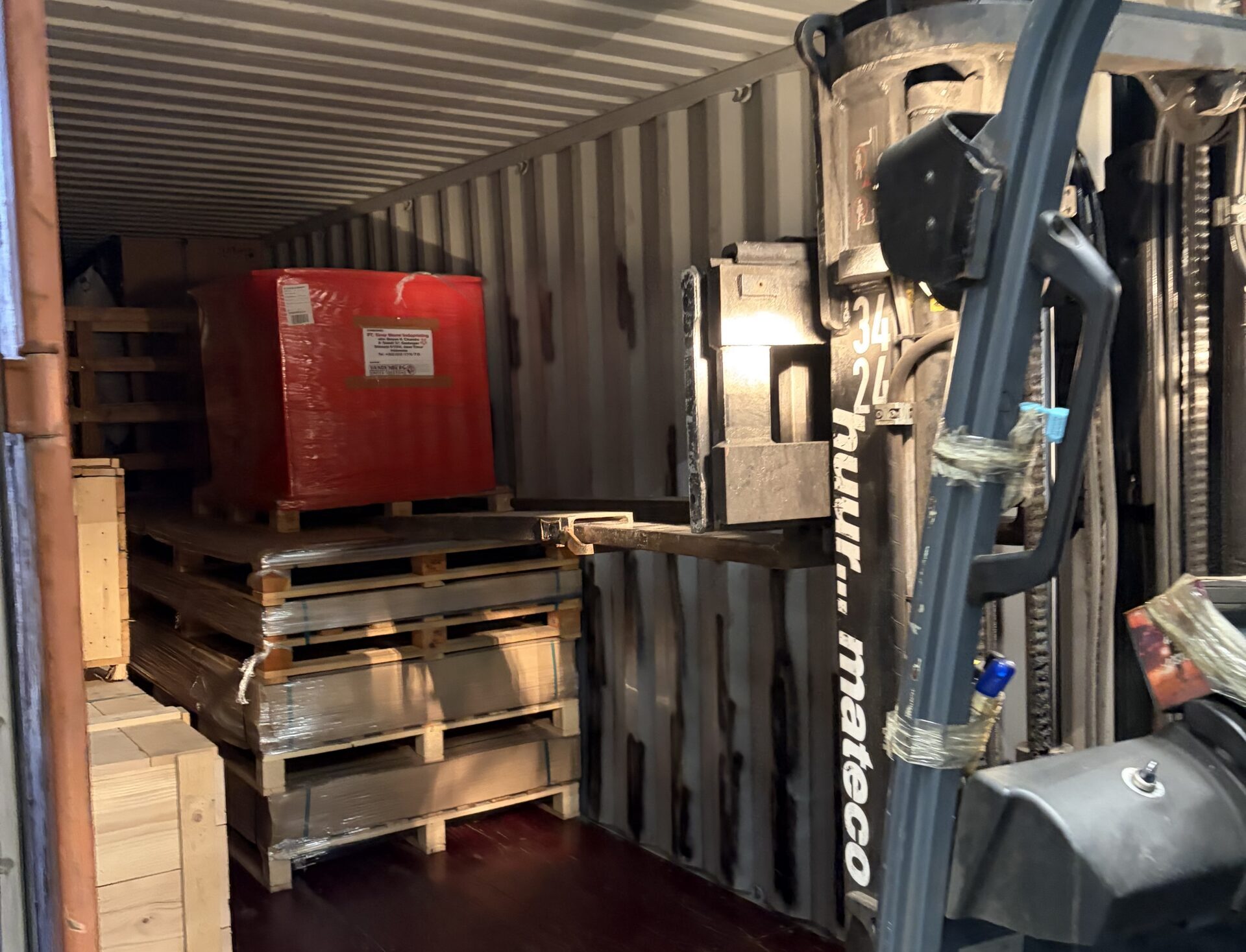 Container with multiple crates inside with a forklift next to it